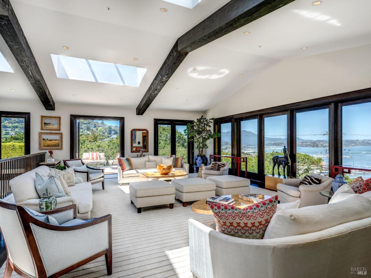 Living room with multiple seating areas and views of the surrounding landscape.