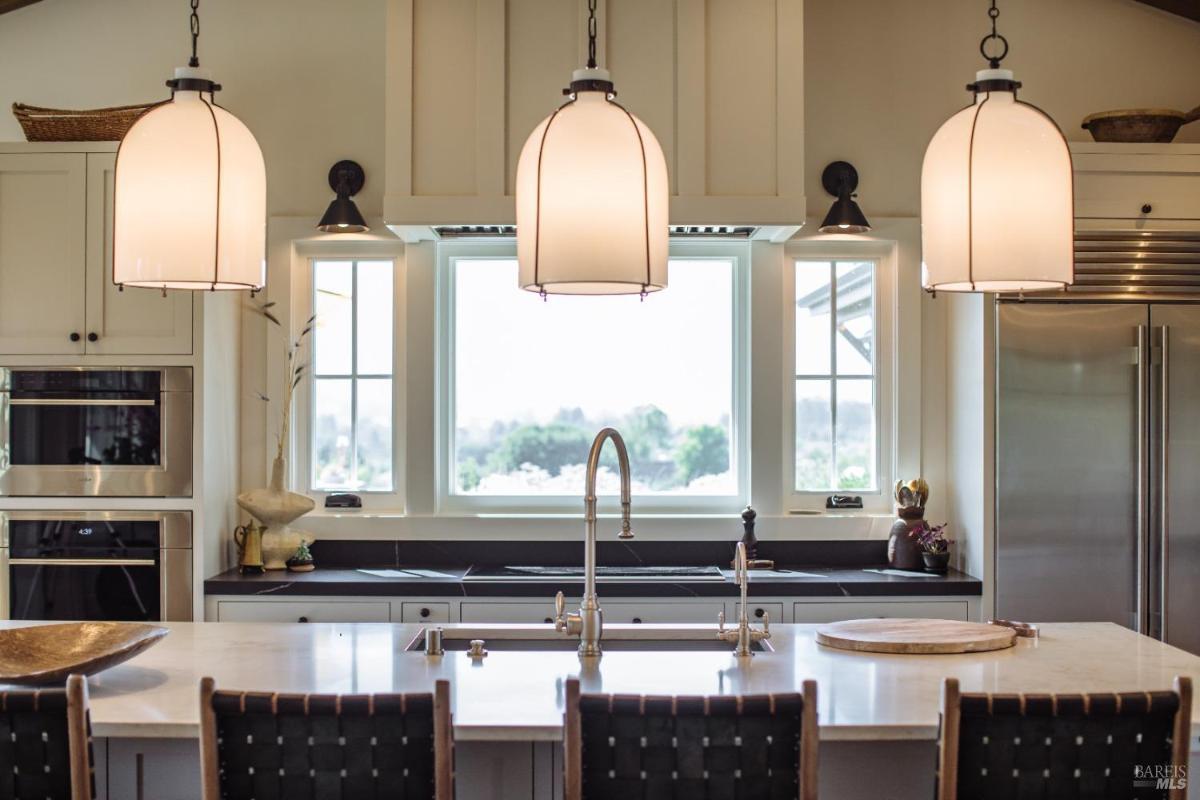 Kitchen with pendant lights, a center island, and built-in appliances.