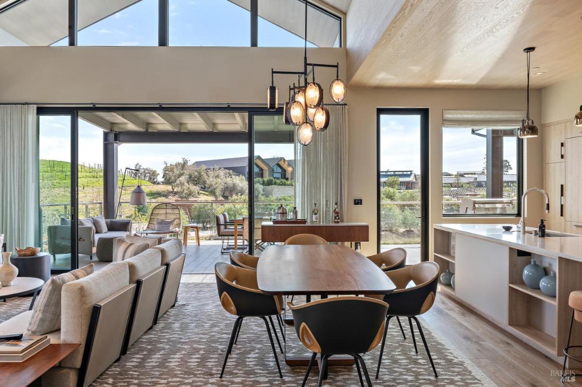 A dining area adjacent to the kitchen, featuring floor-to-ceiling windows and modern lighting.