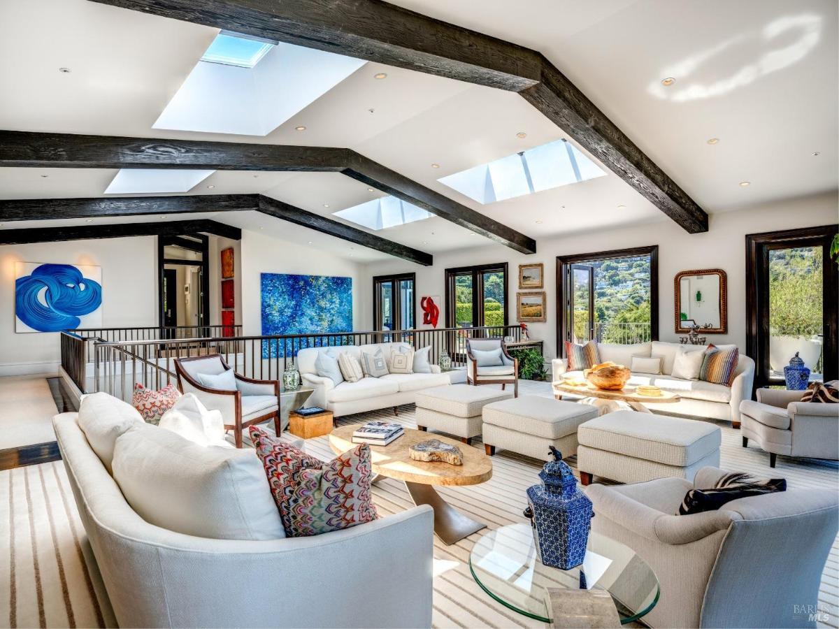 Open living area with art pieces, skylights, and glass doors leading to an outdoor space.