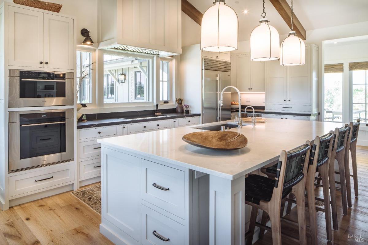 Kitchen with pendant lights, a center island, and built-in appliances.