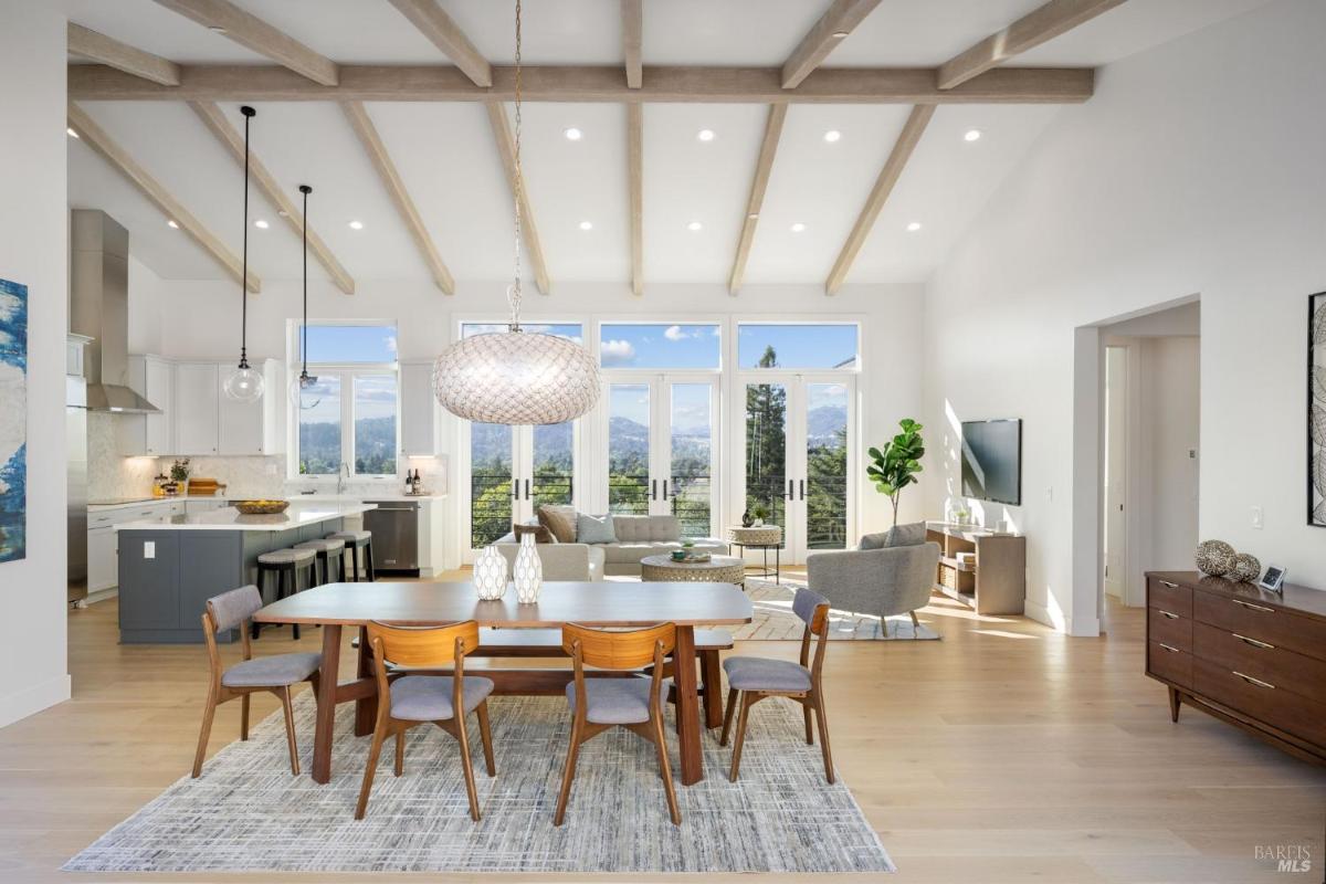 A dining area with a modern light fixture, connected to the living space and kitchen.