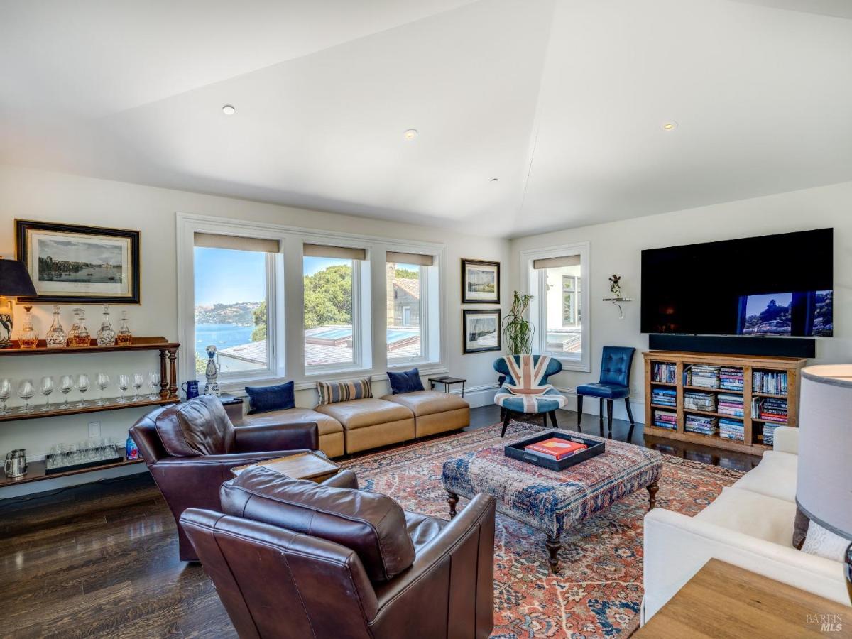 Family room with a sectional sofa, leather armchairs, and a large television.