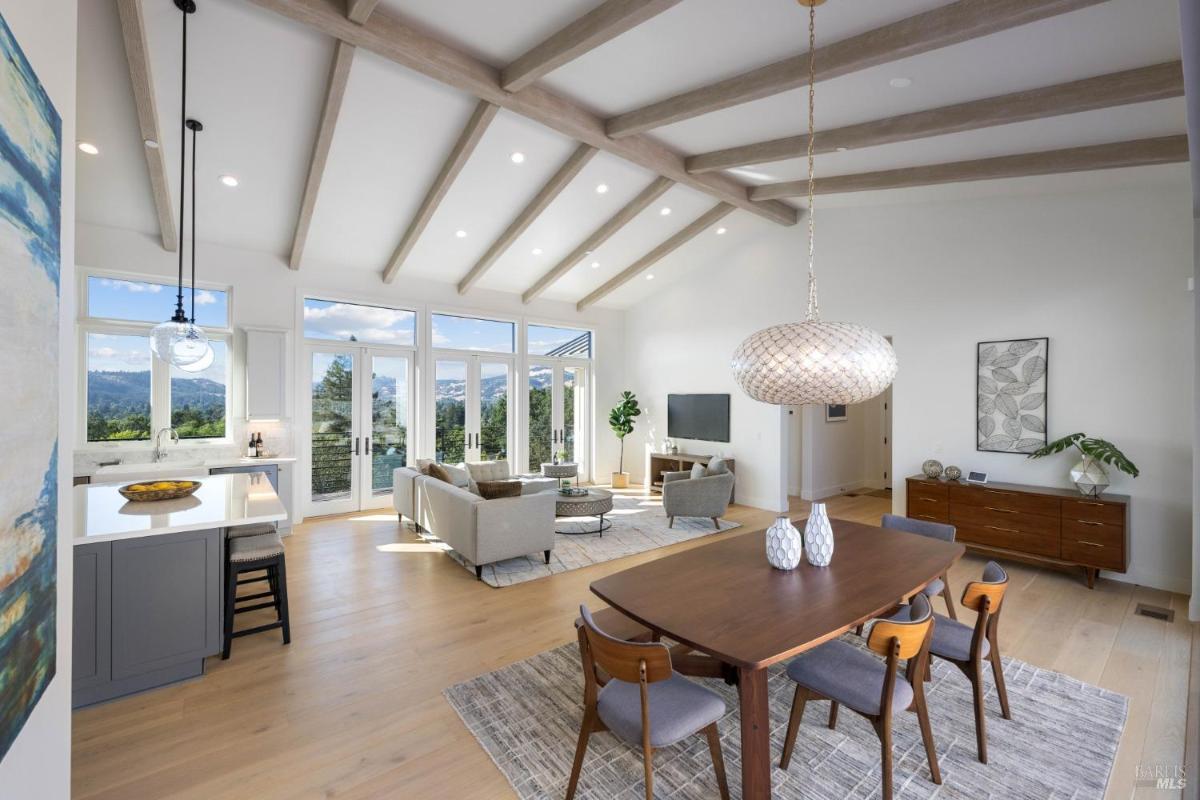 A dining area with a modern light fixture, connected to the living space and kitchen.