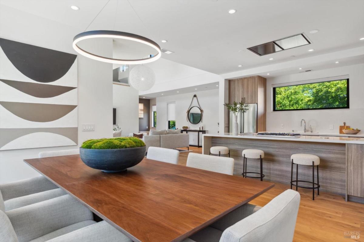 Open dining and kitchen area with modern fixtures and bar seating.