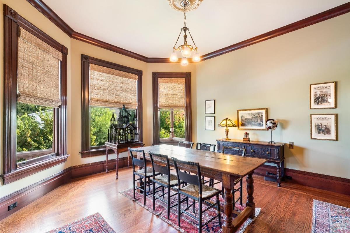 Dining room with a long table, chandelier, and decorative wood accents.