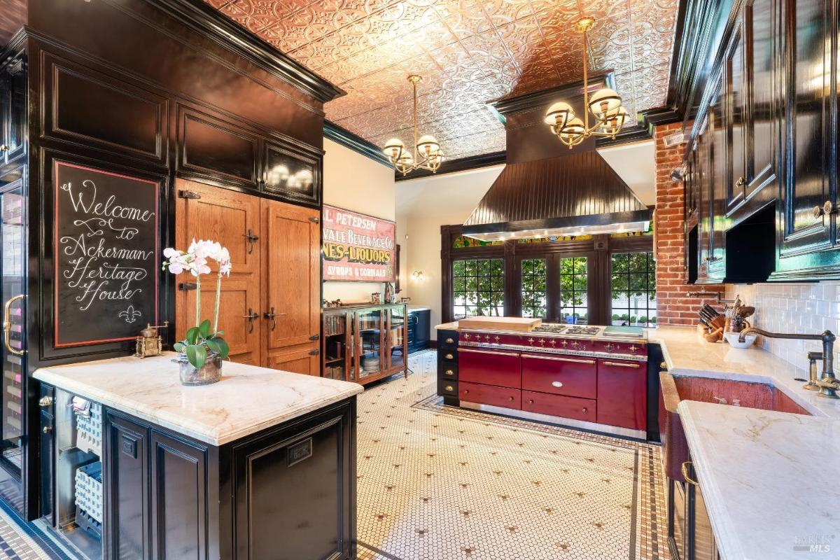 Kitchen with dark cabinets, marble counters, and a center island.