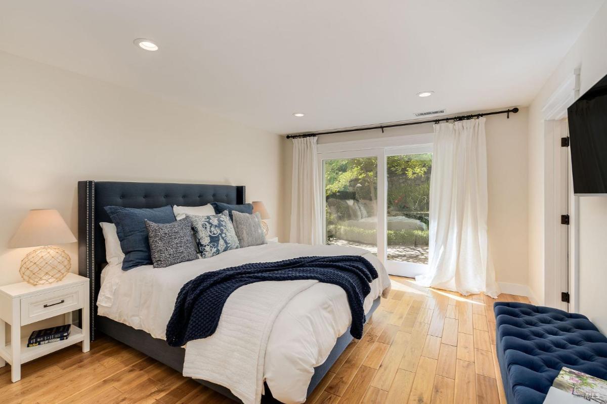 A bedroom with a bed, nightstand, and sliding glass doors leading to a patio.

