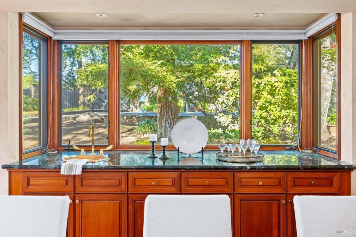 Close-up of a serving station with a countertop, cabinets, and a view of the garden.