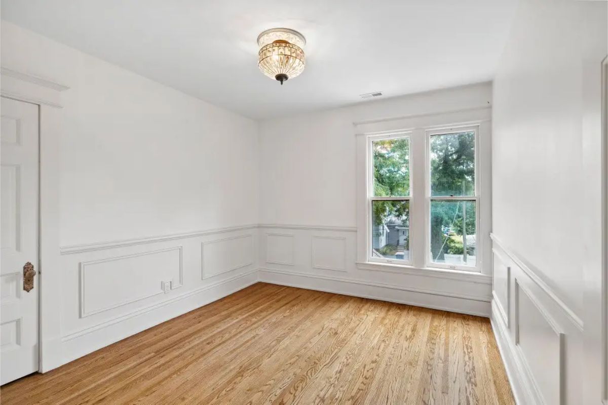 Natural hardwood floors and elegant wainscoting along the walls.