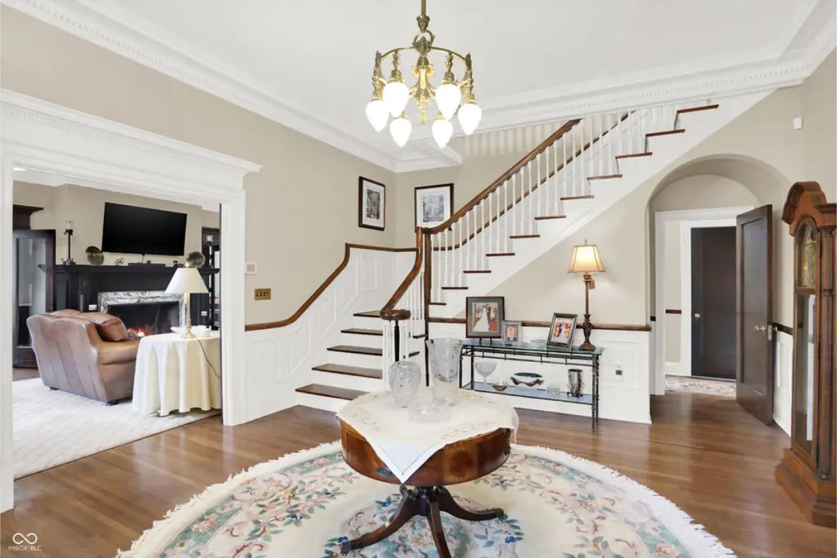 A sweeping staircase with a dark wooden handrail and white spindles.