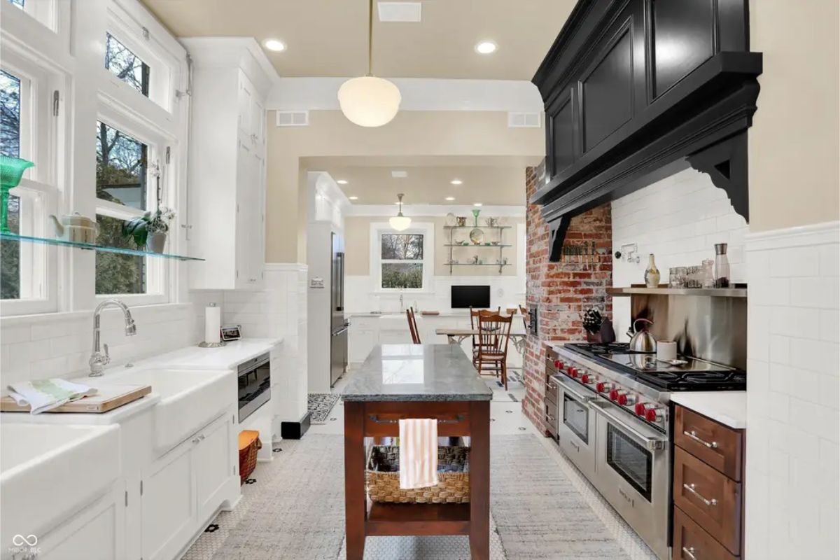 Gourmet kitchen featuring a large island, farmhouse sink, and premium stainless-steel appliances. 