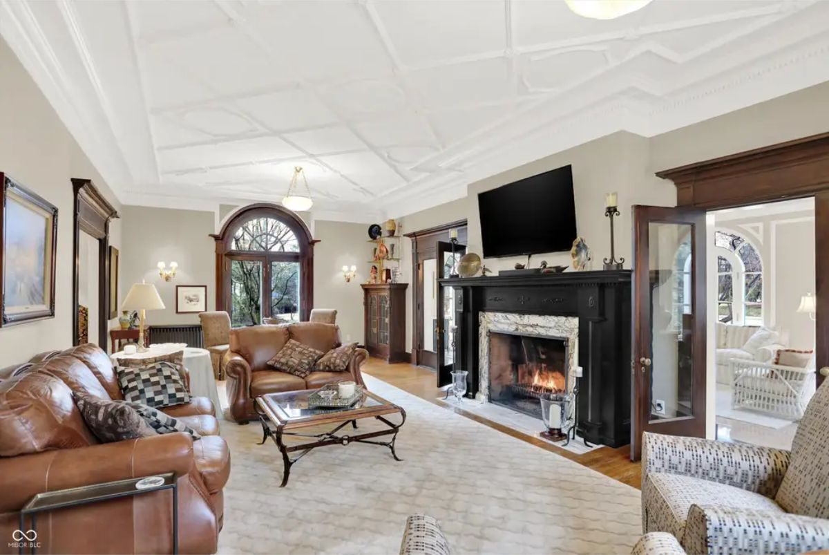 Spacious living room with intricate coffered ceilings and arched windows allowing ample natural light.