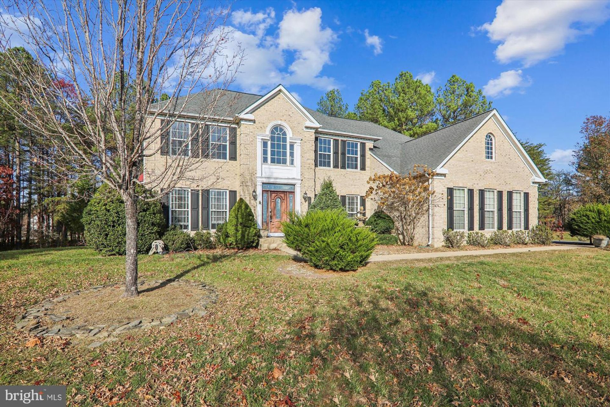 Expansive front yard view showcasing the brick home and lush landscaping.