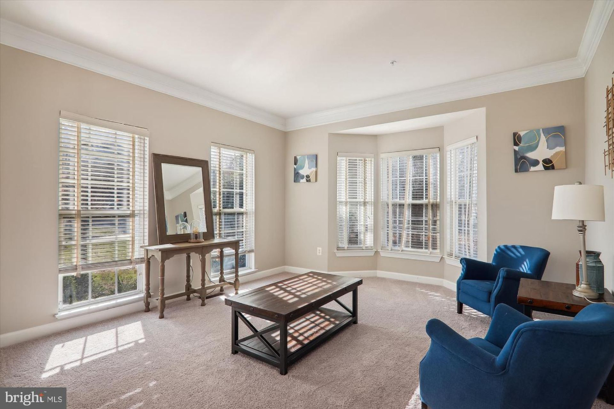 Bright sitting room with a bay window and abundant natural light.