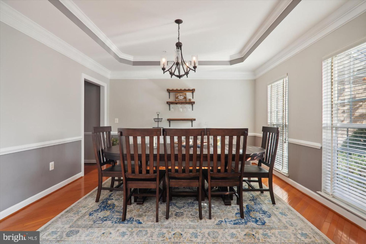 Formal dining room with a large wooden table and chandelier.