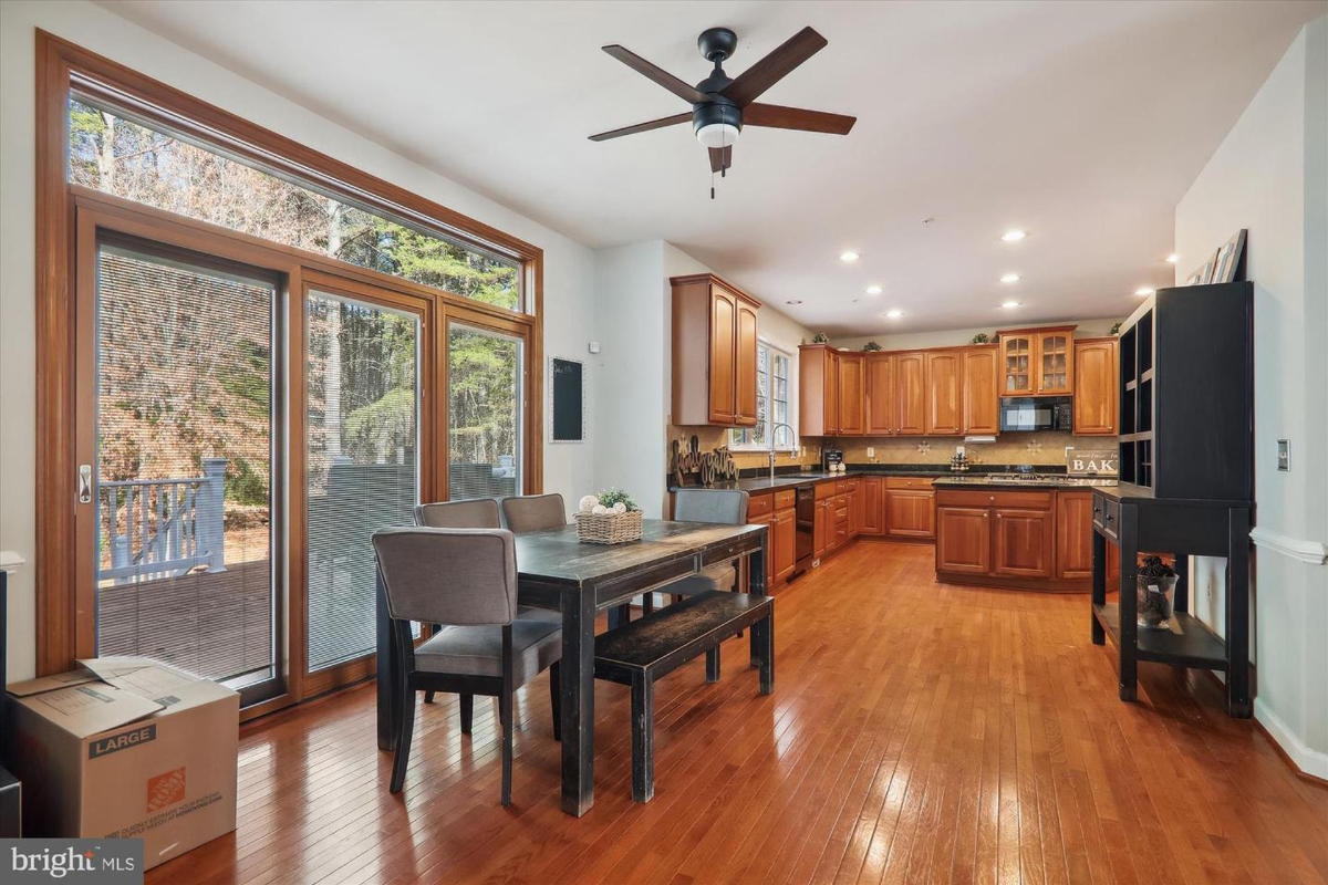 Spacious kitchen with wood cabinets, granite countertops, and access to the outdoor deck.