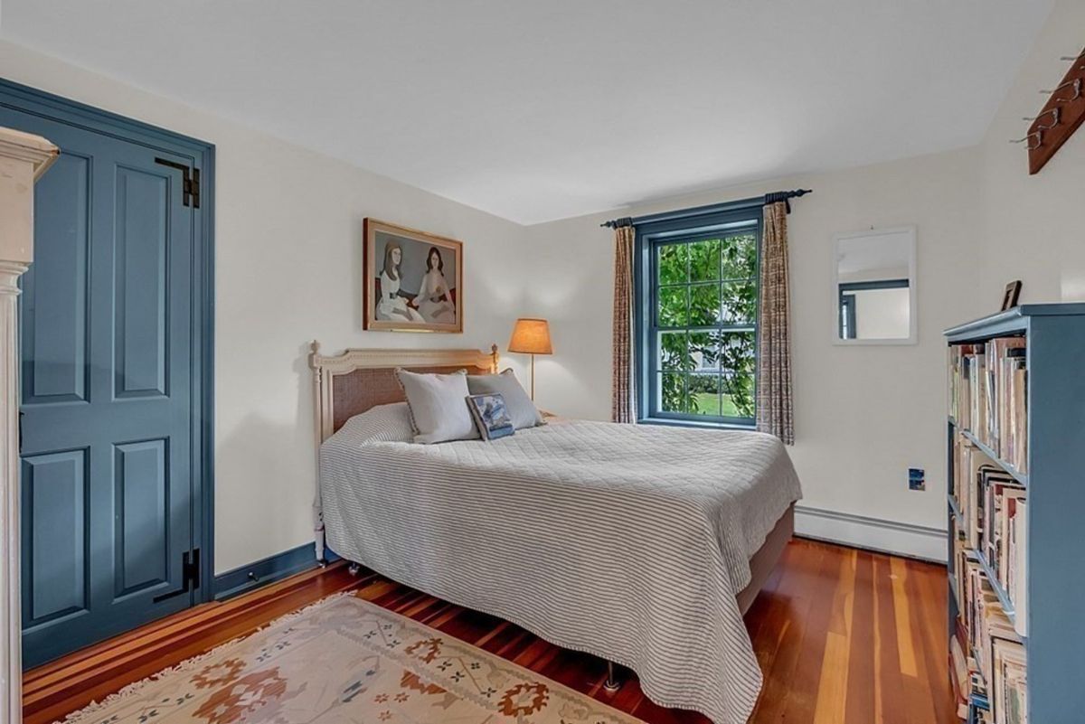 Minimalist bedroom with a soft color palette and rich wooden flooring.