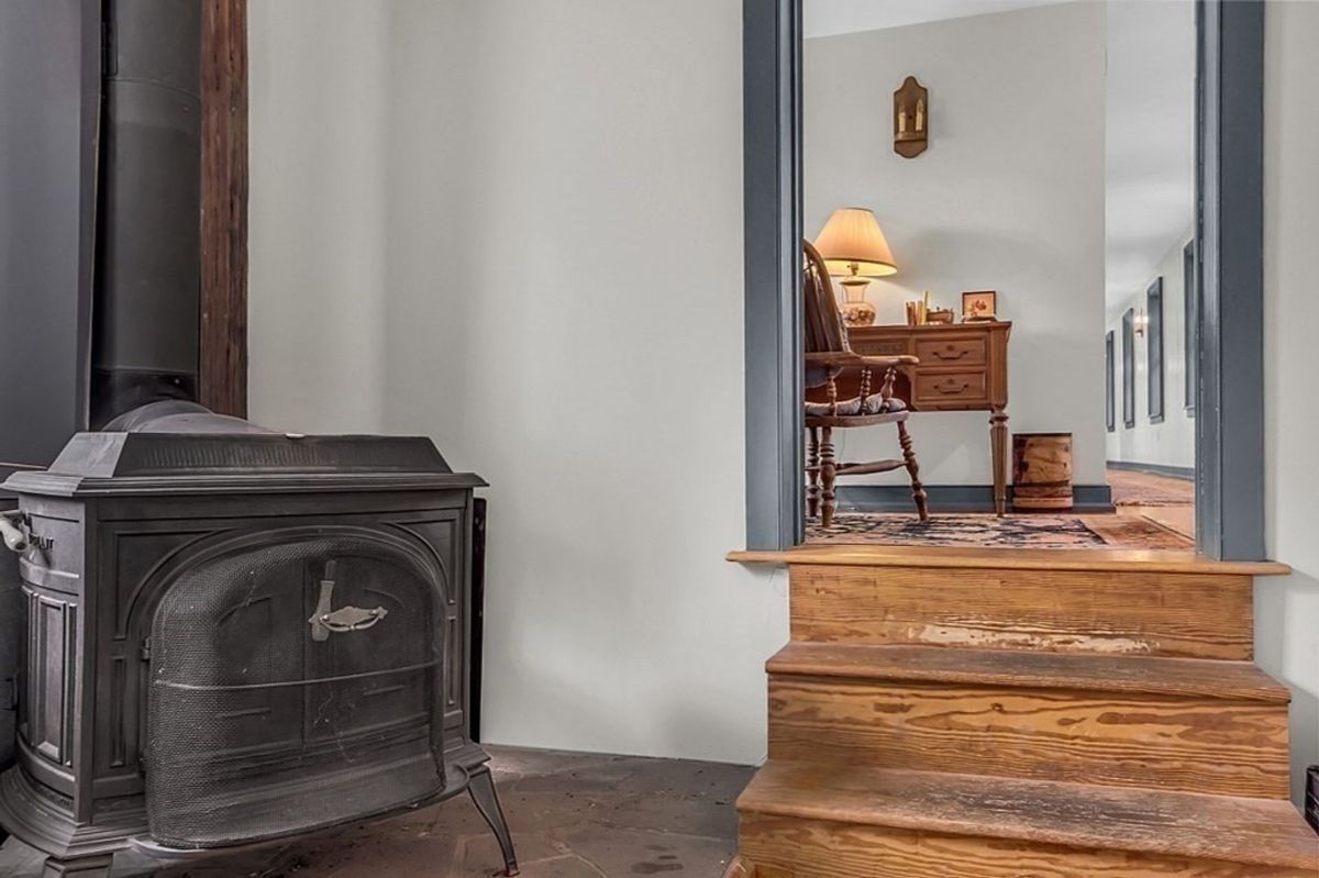 Rustic room entrance with a wood stove and stone flooring.