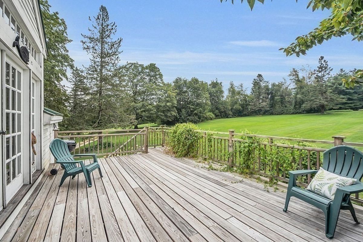 Wooden deck overlooking expansive green lawns.