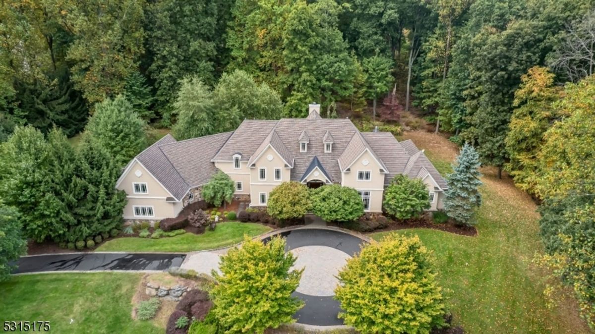 Nestled within lush greenery, this estate features a circular driveway and expansive architectural elegance.