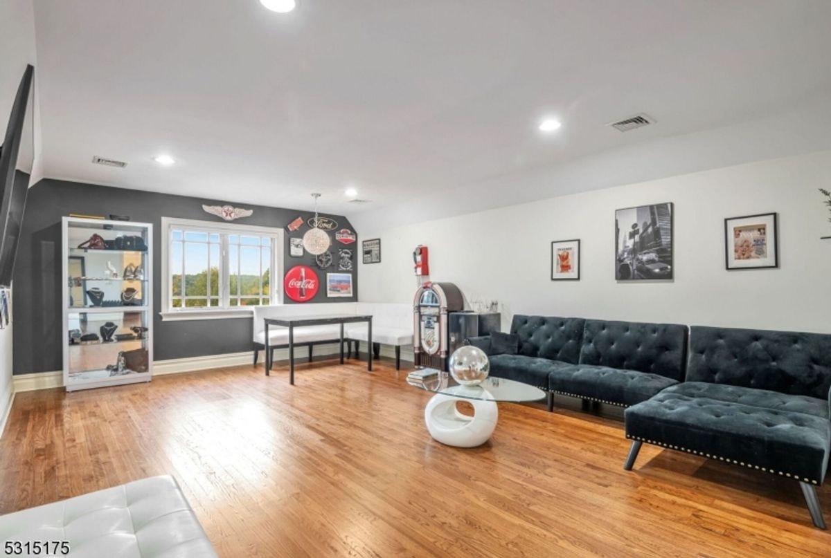 Stylish recreation room features vintage decor, a jukebox, and plush seating for a retro-inspired entertainment space.