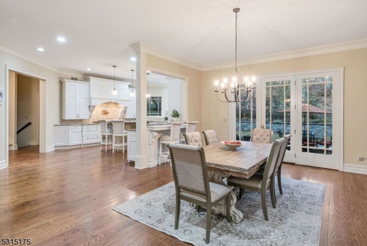 An open dining area transitions seamlessly into a bright kitchen with a large island and bar seating.