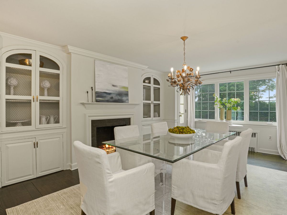 Dining room featuring a glass table, built-in cabinets, and a statement chandelier.