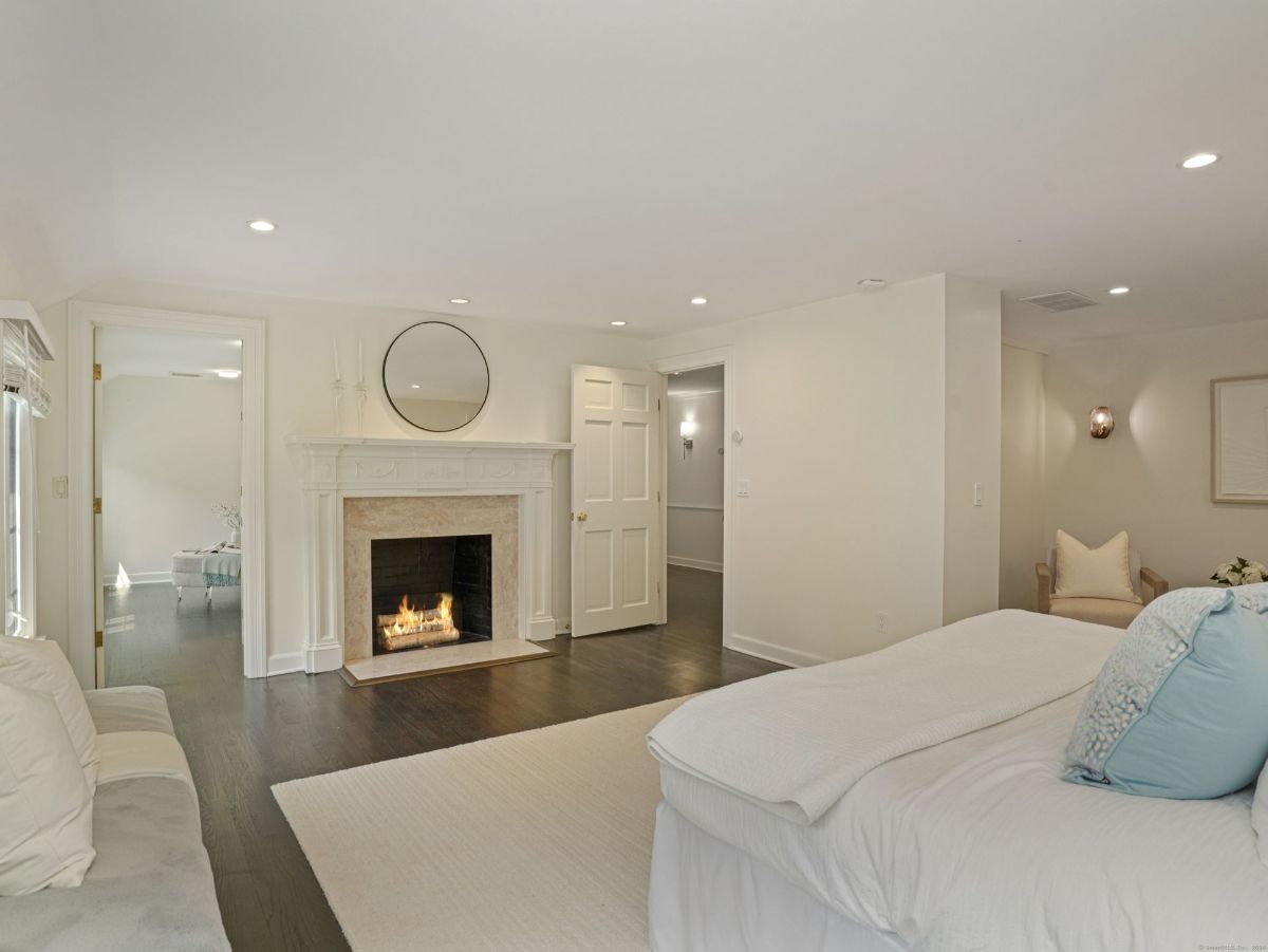 Bedroom with a cozy fireplace, soft lighting, and minimal decor.