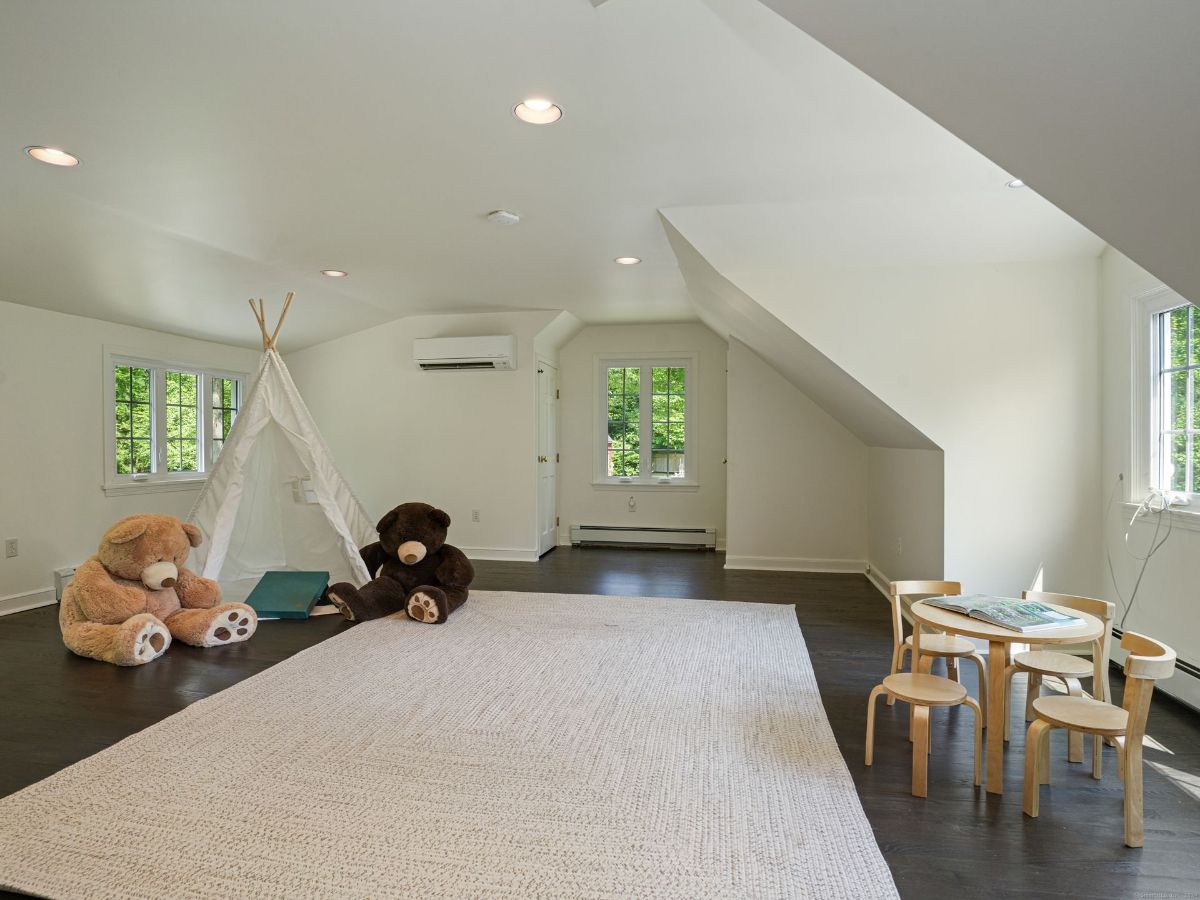 Spacious playroom with a teepee, plush toys, and a cozy seating area for kids.