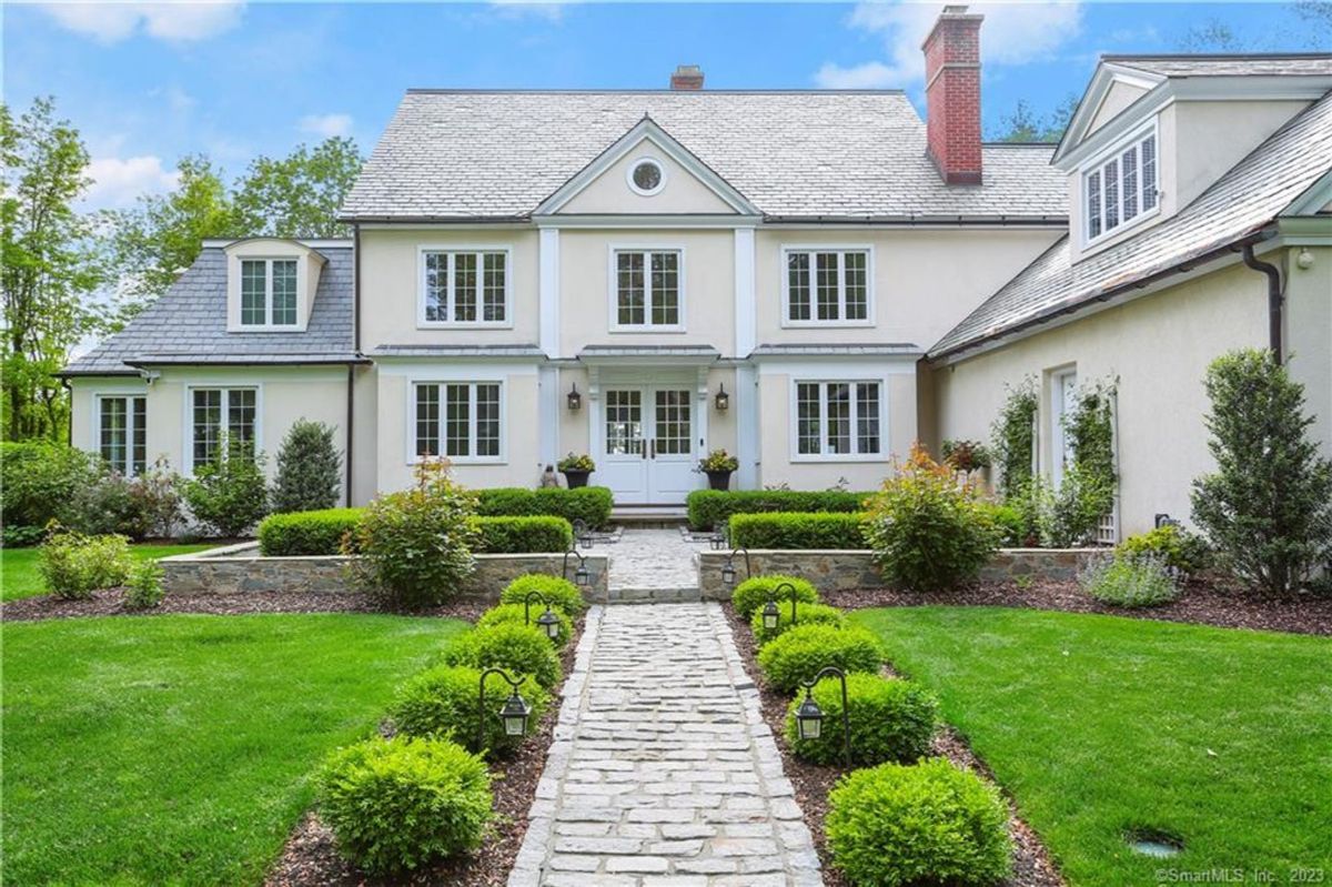 Elegant house with stone walkway and landscaping.