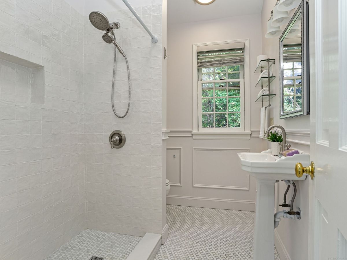 Updated bathroom with a walk-in shower, sleek tilework, and elegant fixtures.