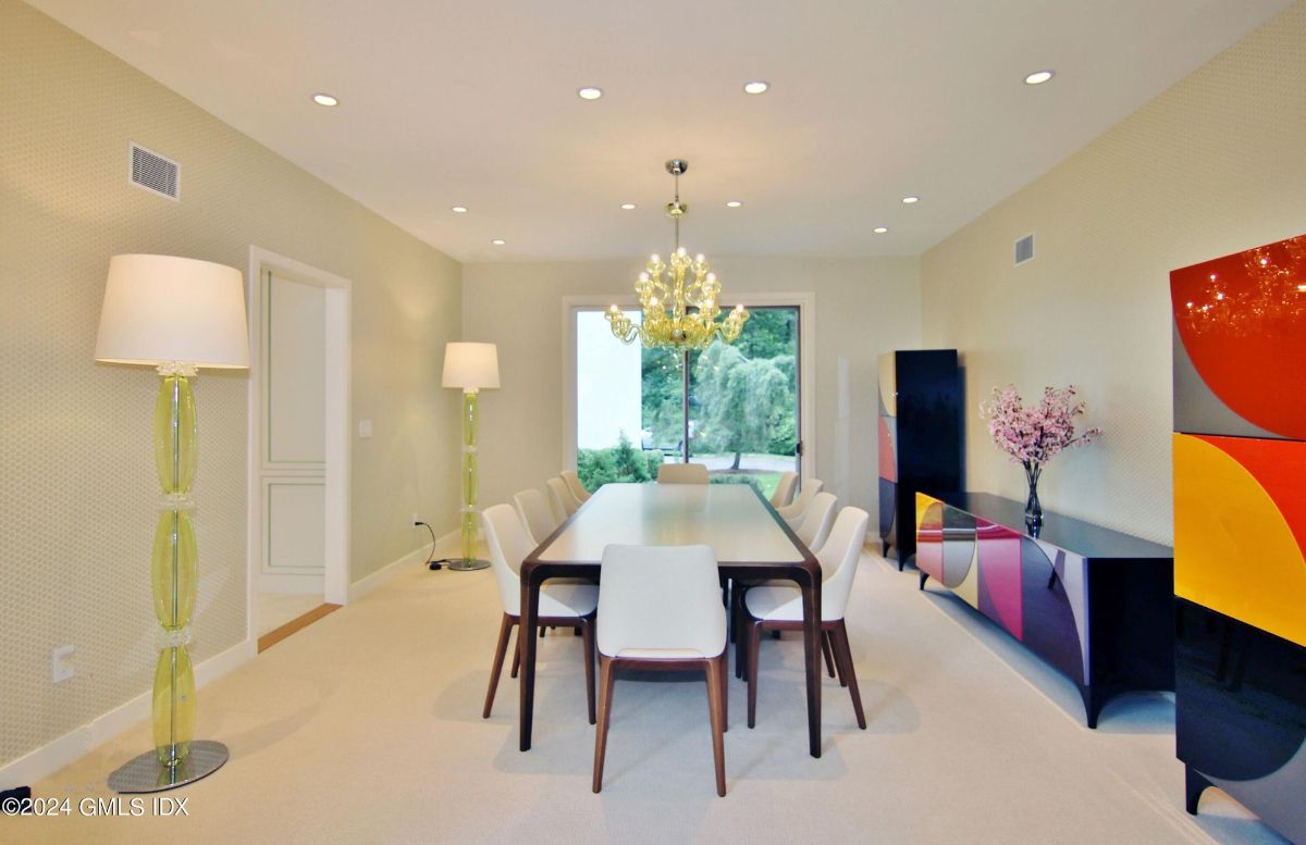 Dining room combines bold geometric cabinetry and elegant furnishings with a central chandelier for a striking yet inviting ambiance.