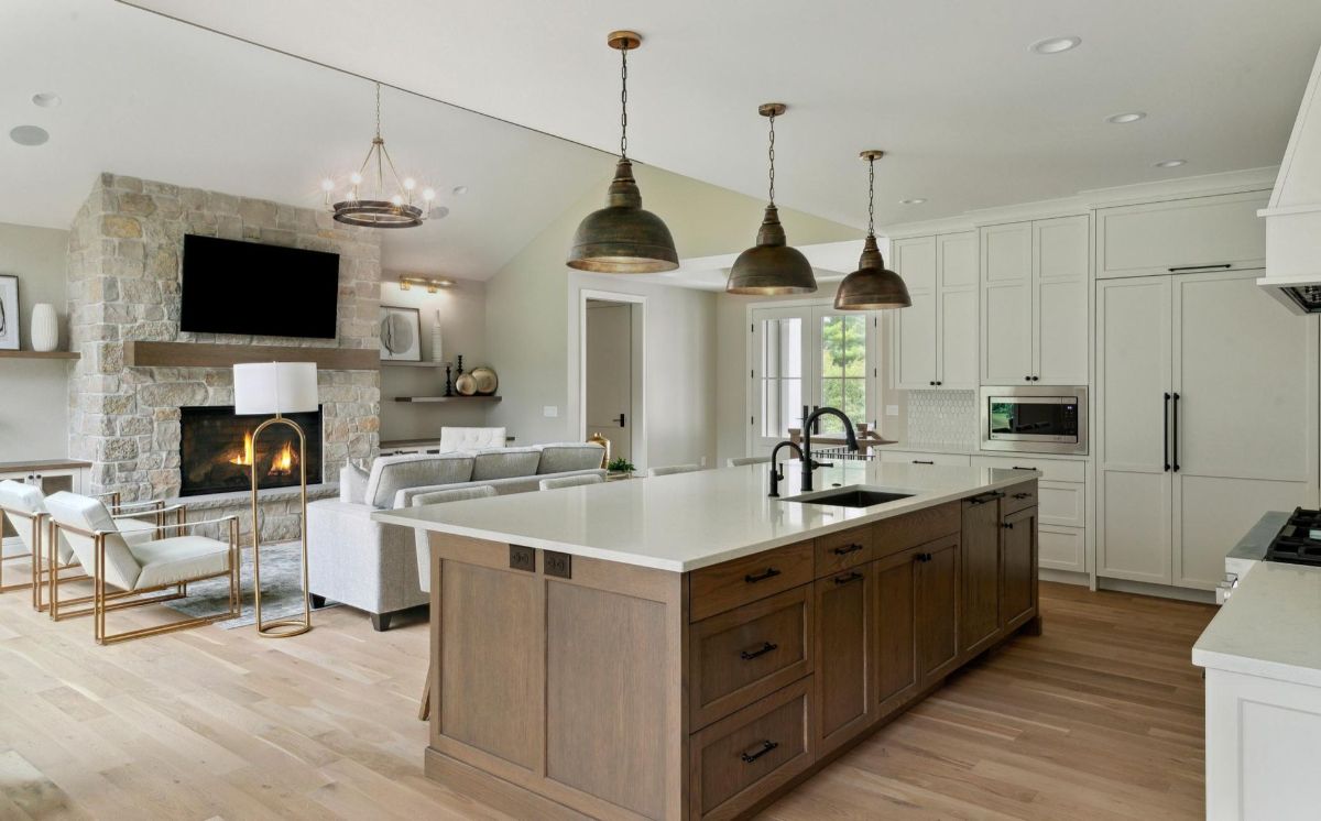 A warm kitchen island anchors the open layout with a stone fireplace and cozy seating.