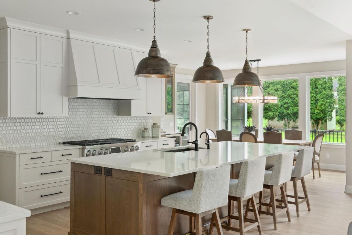 An inviting kitchen showcases a long island with seating, pendant lighting, and a tiled backsplash.