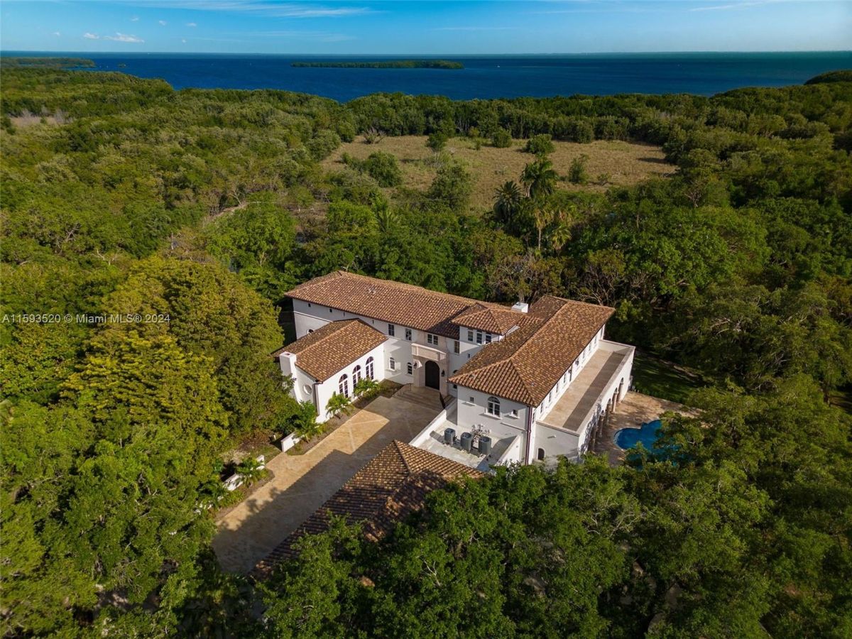 Mediterranean estate with lush greenery and water views.