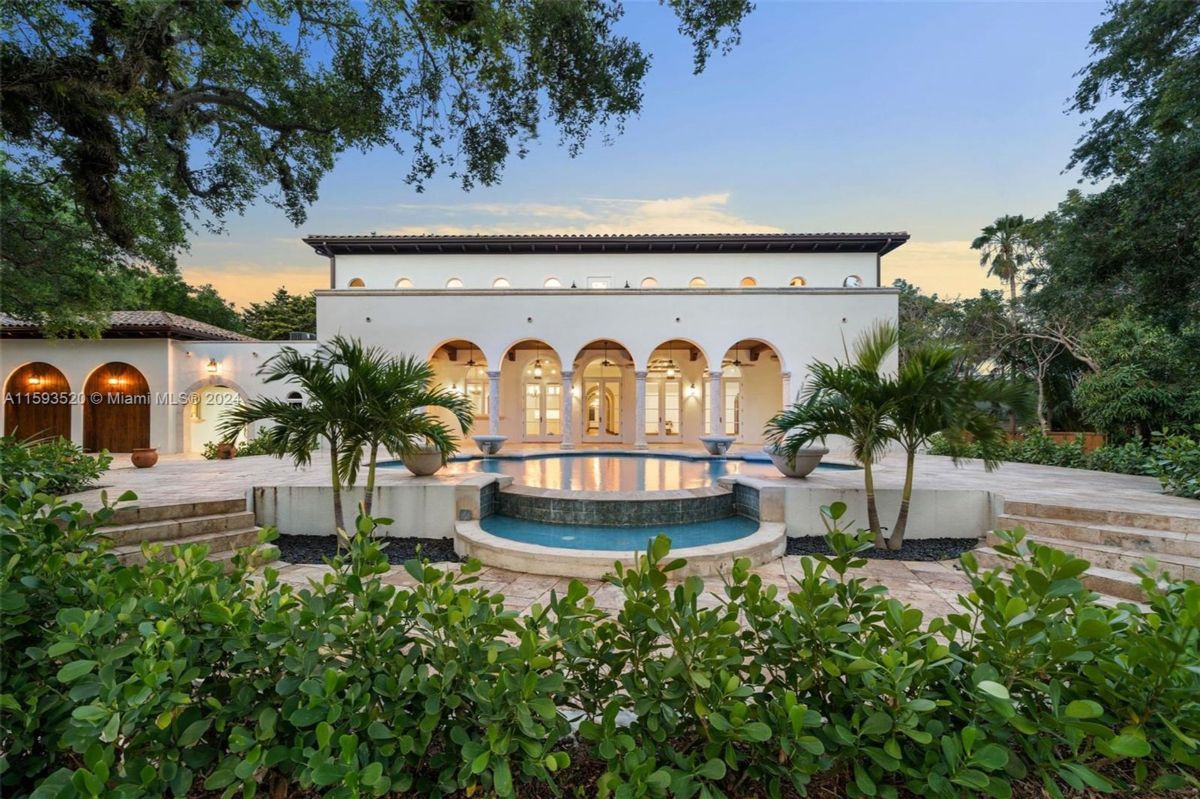 Resort-style pool area framed by tall arches and columns.