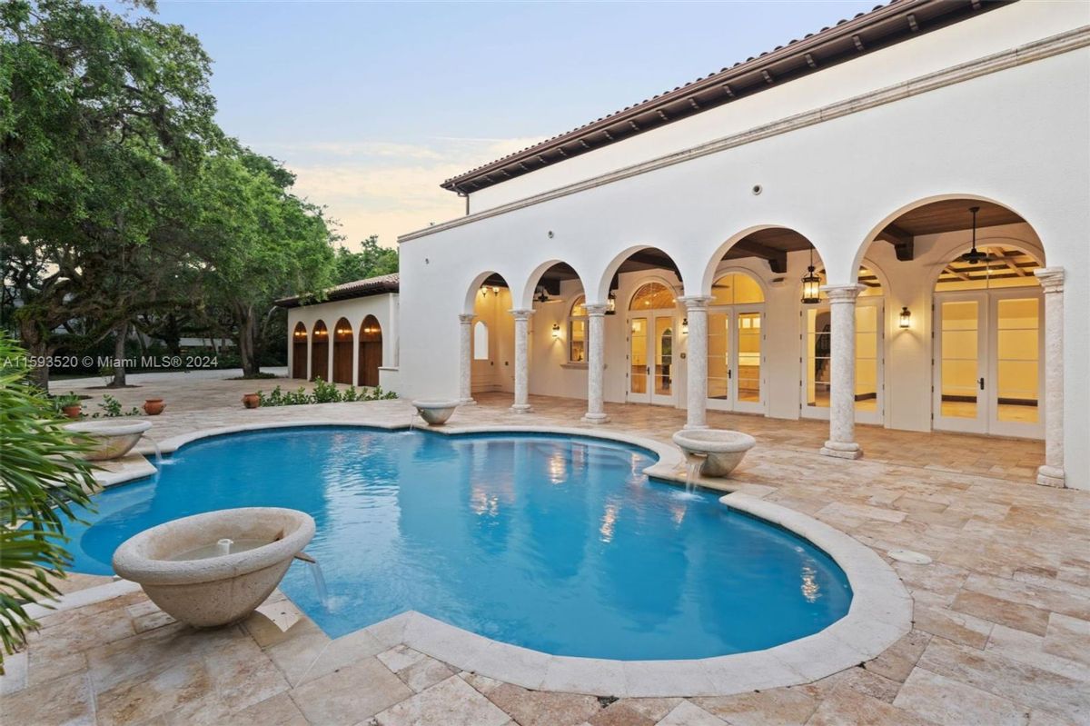 Expansive pool terrace featuring arched colonnades and soft evening lighting.