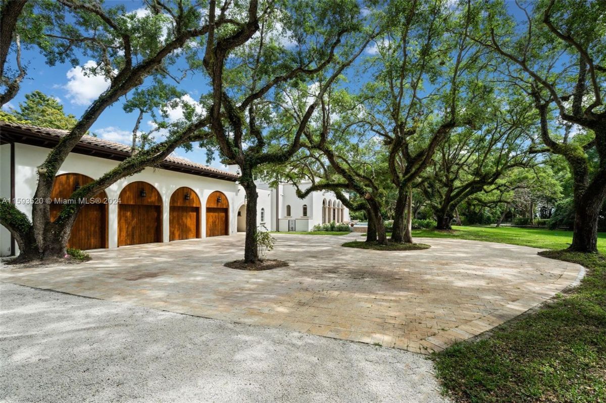 Circular driveway lined by oak trees 