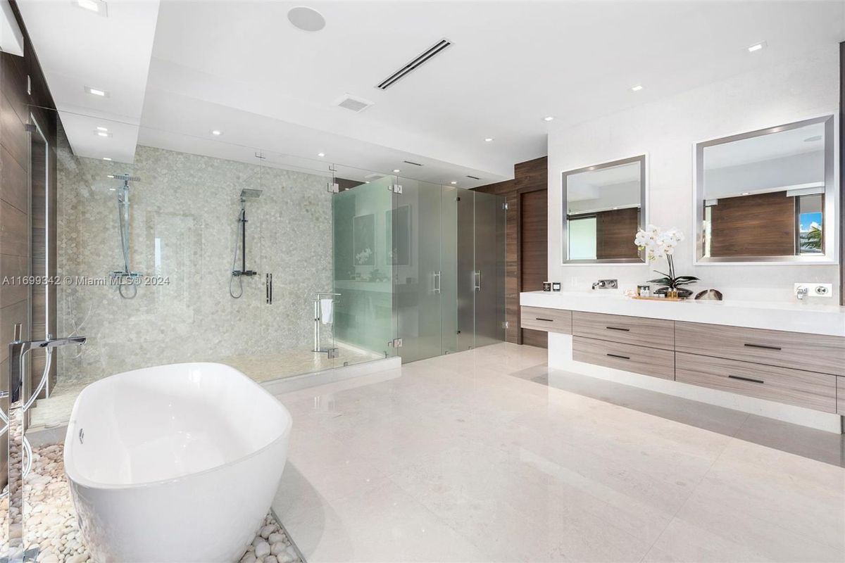 Luxurious bathroom with soaking tub, dual rain showers, and sleek double vanity.