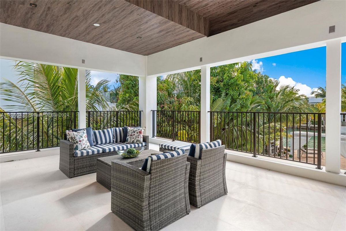 Outdoor seating area with striped cushions surrounded by tropical greenery.