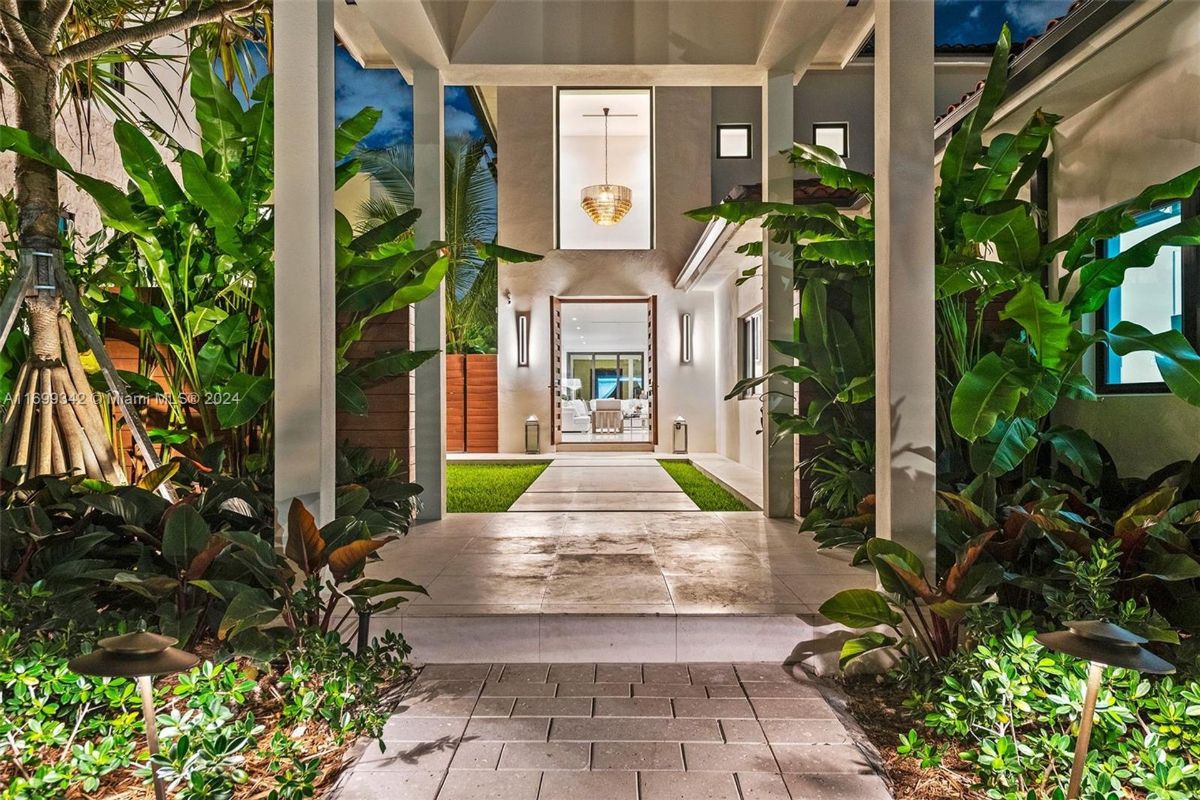 Entryway leading to a grand illuminated doorway framed by sleek modern architecture.