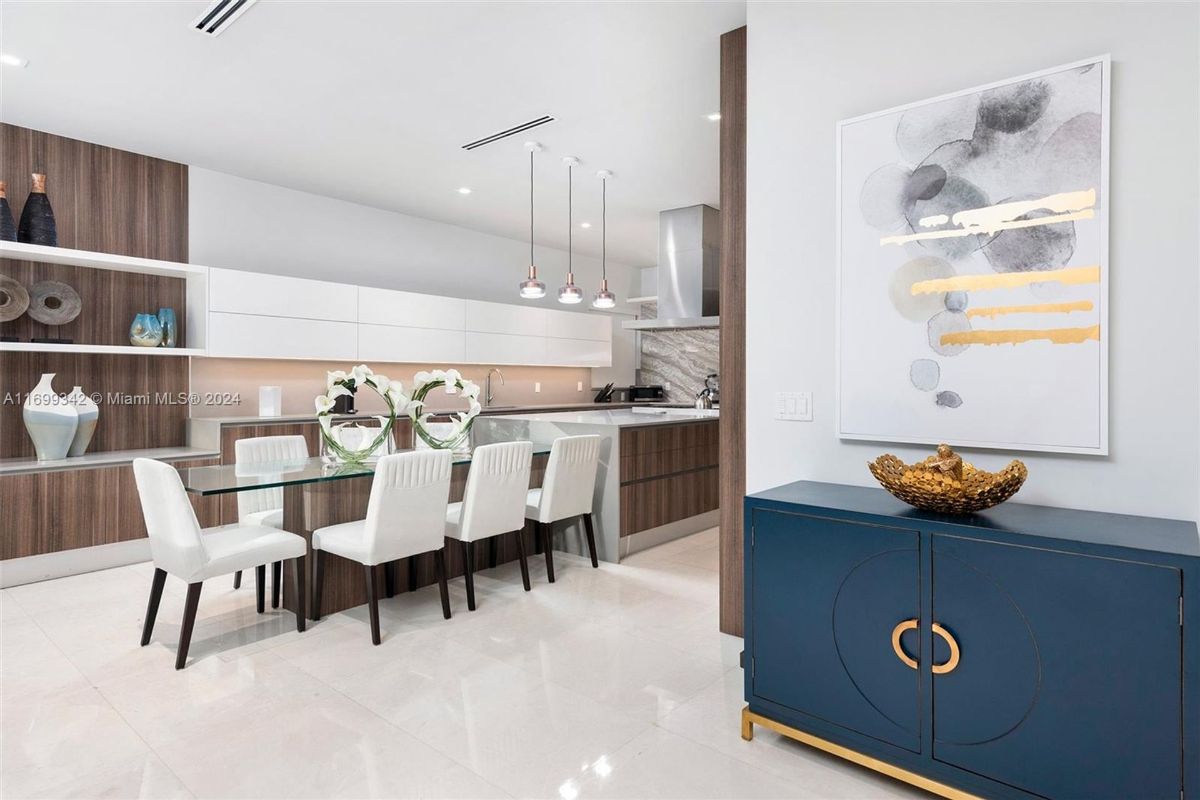 Dining area with sleek wood accents, a glass-top table, and contemporary lighting.