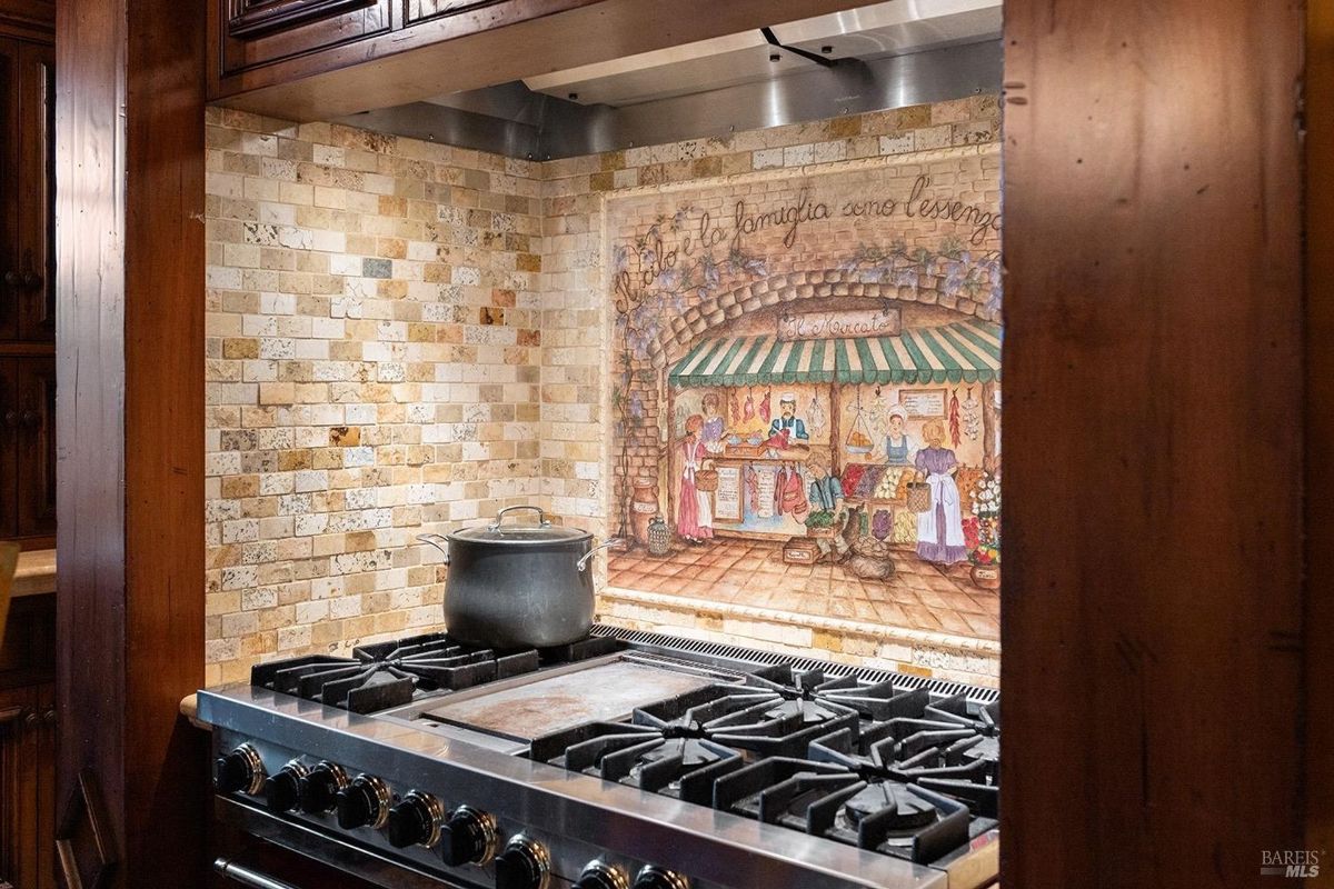 Rustic kitchen design featuring exposed wood beams, custom cabinetry, and a bold red stove.