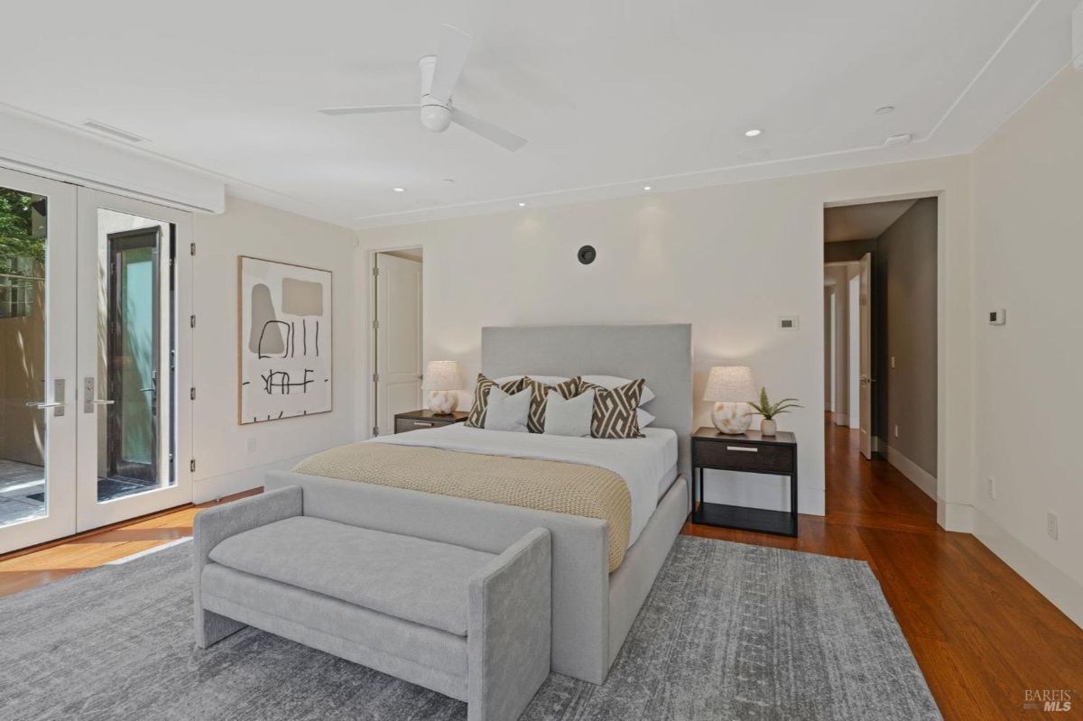 Spacious bedroom with neutral tones, modern furnishings, and access to a private patio.