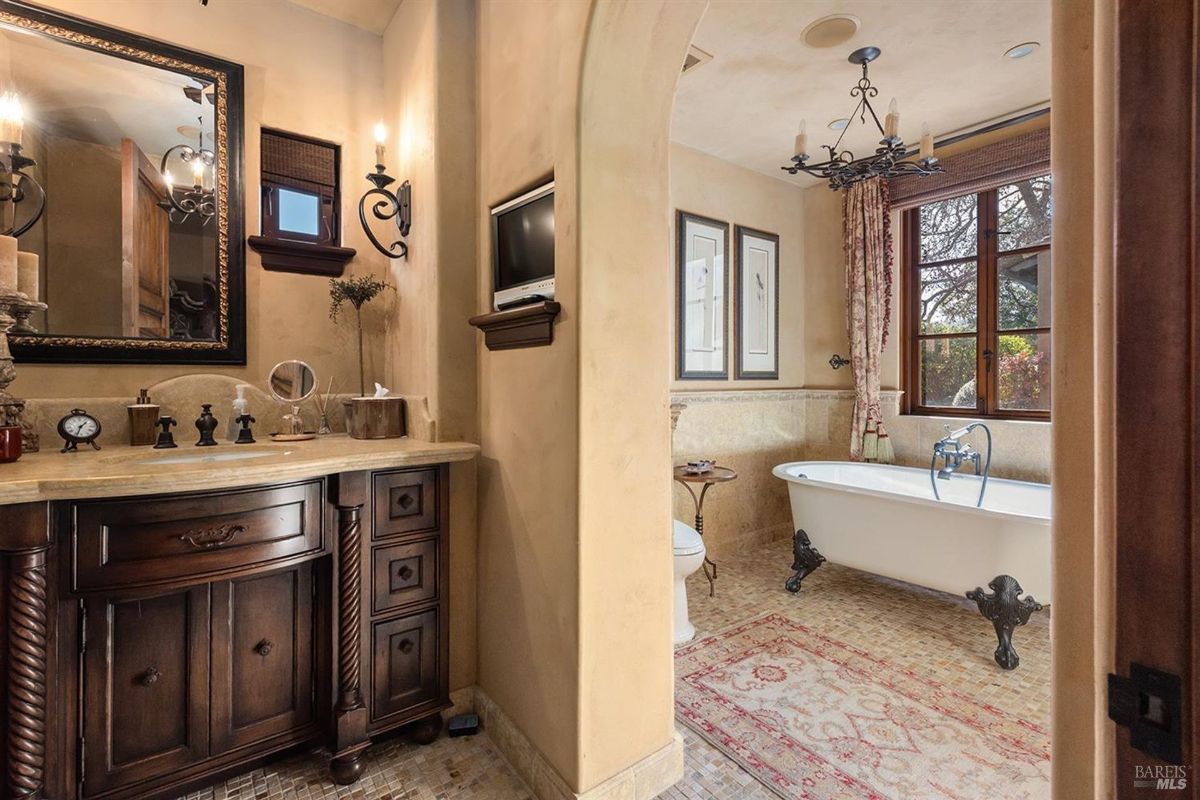 "Luxurious bathroom featuring a clawfoot tub, ornate fixtures, and warm wood accents."