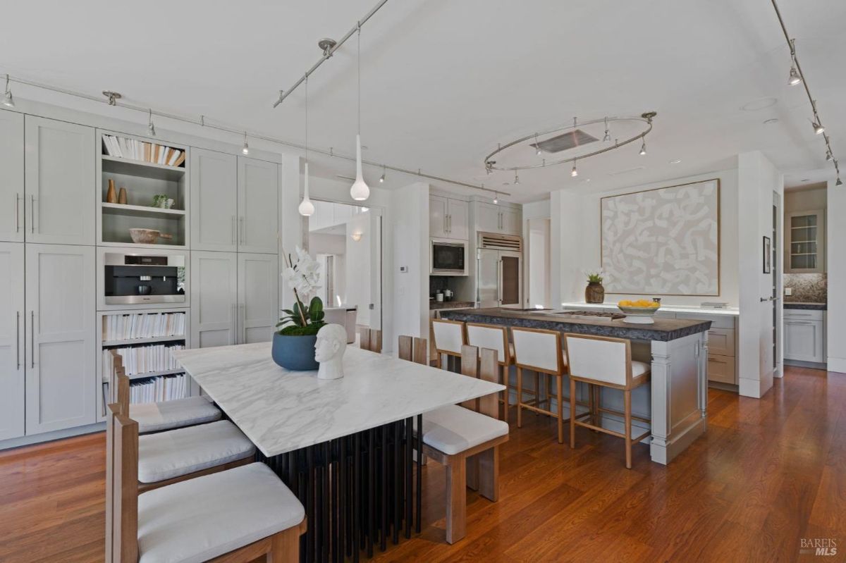 Sleek kitchen design featuring marble accents, modern lighting, and ample cabinetry.