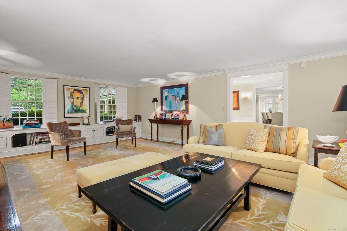 Living room with custom built-ins, elegant seating, and large windows that flood the space with natural light.