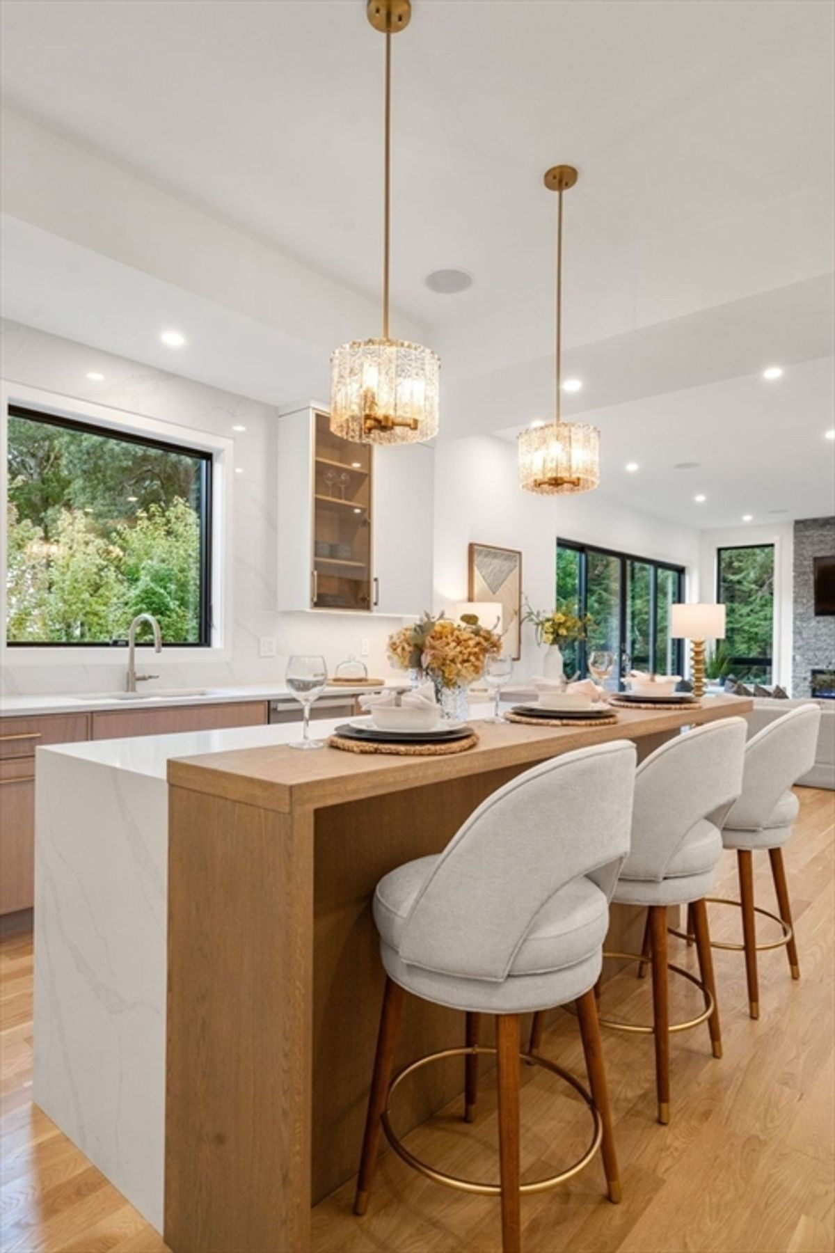 Kitchen island with wooden accents, cozy bar stools, and chic pendant lighting creating a warm and inviting space.