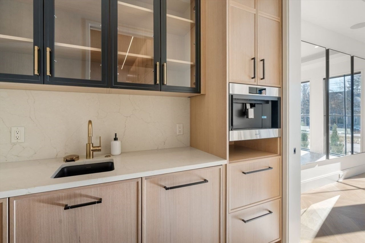 Stylish coffee bar setup with sleek cabinetry and a built-in coffee machine.